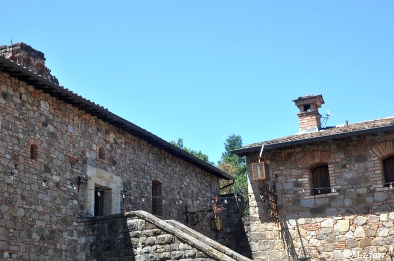 Castello Di Amorosa: каменные стены и кирпичные трубы под ясным небом